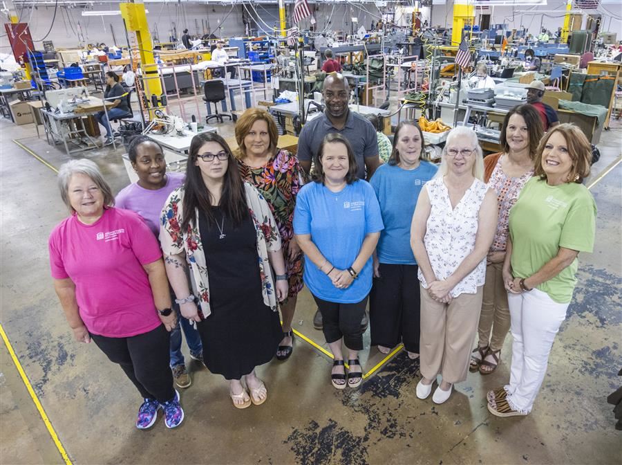  Members of the Alabama Industries for the Blind Customer Service Department smile to camera.